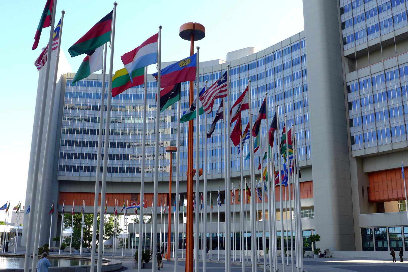 Das Gebäude der United Nations in Wien. Vor dem Gebäude sind die Flaggen aller Nationen der Vereinten Nationen zu sehen.