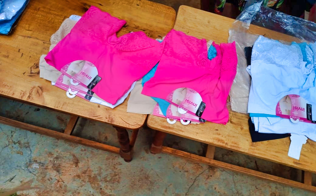 Verschiedenfarbige Damenunterwäsche auf einem Brett ausgelegt.