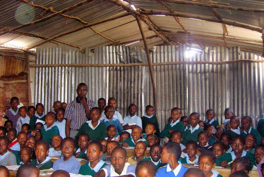 Eine große Ansammlaung Schulkinder in einem Wellblech-Klassenzimmer ohne Fenster.