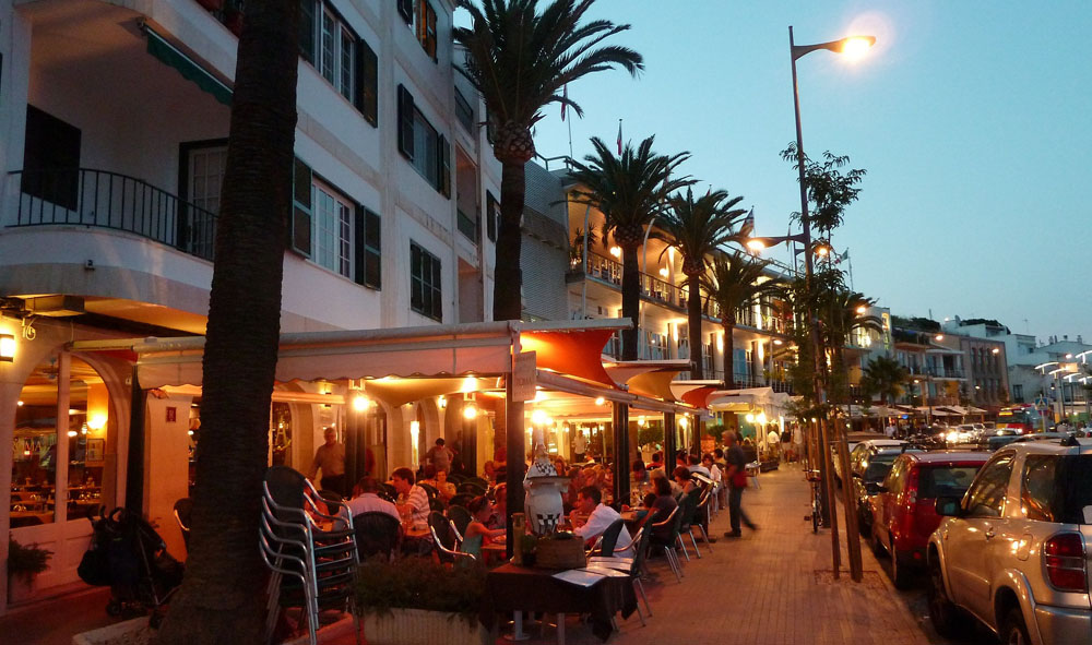 Strassencafes in Abendstimmung mit Palmen und Laternenbeleuchtung