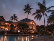 Abendstimmung mit Palmen. Eine schöne Hotelanlage. Im Vordergrund ein Swimmingpool.