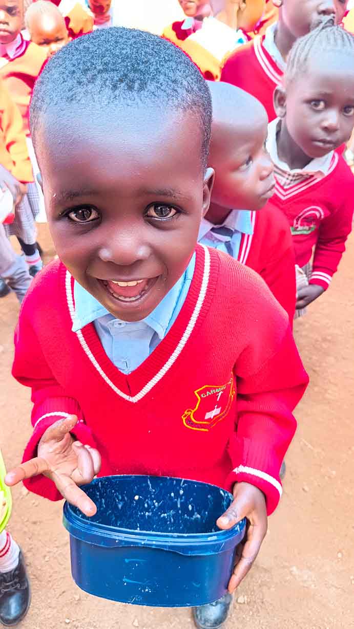 Lächelnder Junge in roter Schuluniform — Patenkind von Planet Children