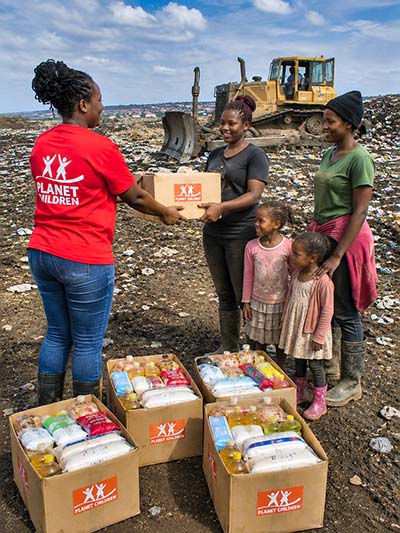 &Uuml;bergabe von FoodBoxen mit Lebensmitteln an eine Mutter mit Kindern in Kenia.
