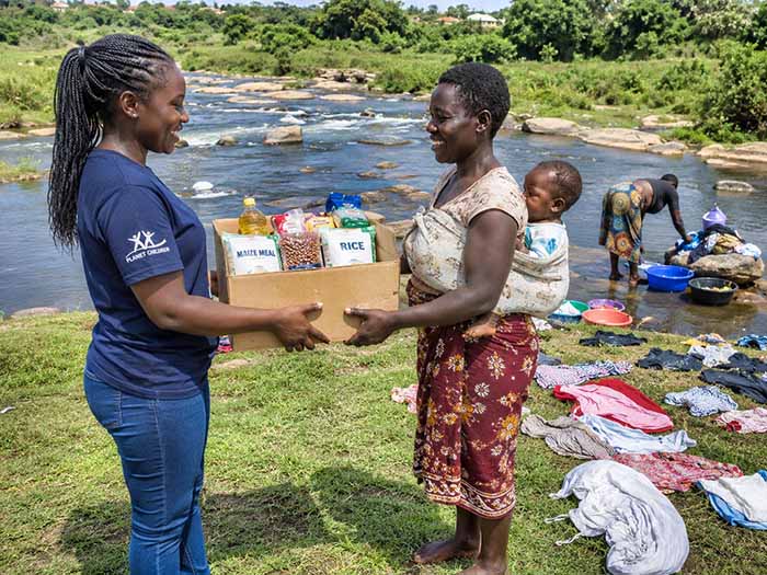 &Uuml;bergabe einer FoodBox mit Lebensmitteln an eine Mutter mit Kind in Kenia.