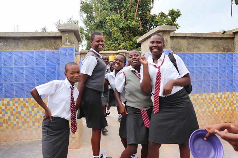 Schülerinnen vor den neuen Sanitäranlagen ihrer Schule in Afrika