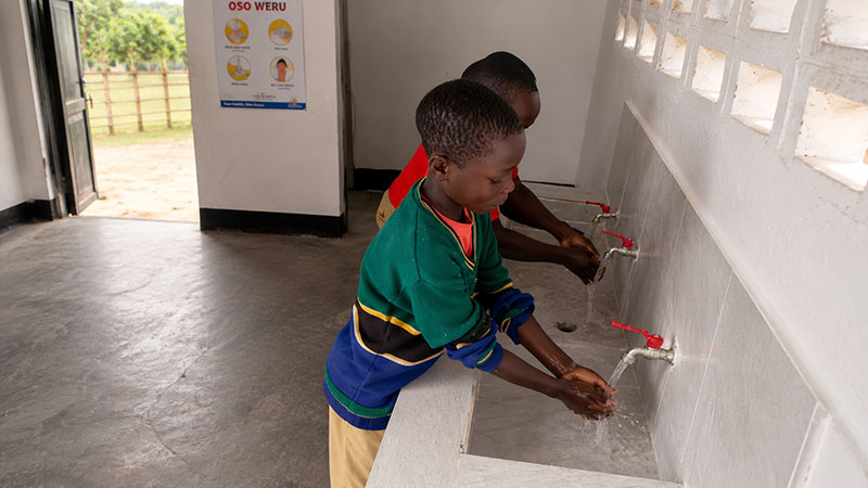 Kinder in Tansania waschen sich die Hände – eine gute Infrastruktur unterstützt Bildung der Kinder. 